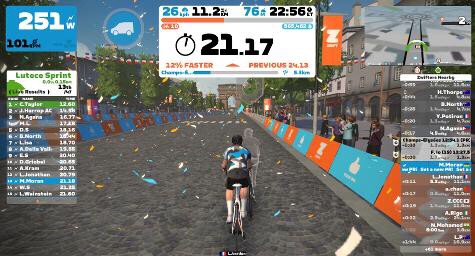 Picture shows a screenshot from the indoor cycling app Zwift showing a cycling avatar on a virtual Champs-Élysées in Paris with data showing speed, distance covered and the leader board.