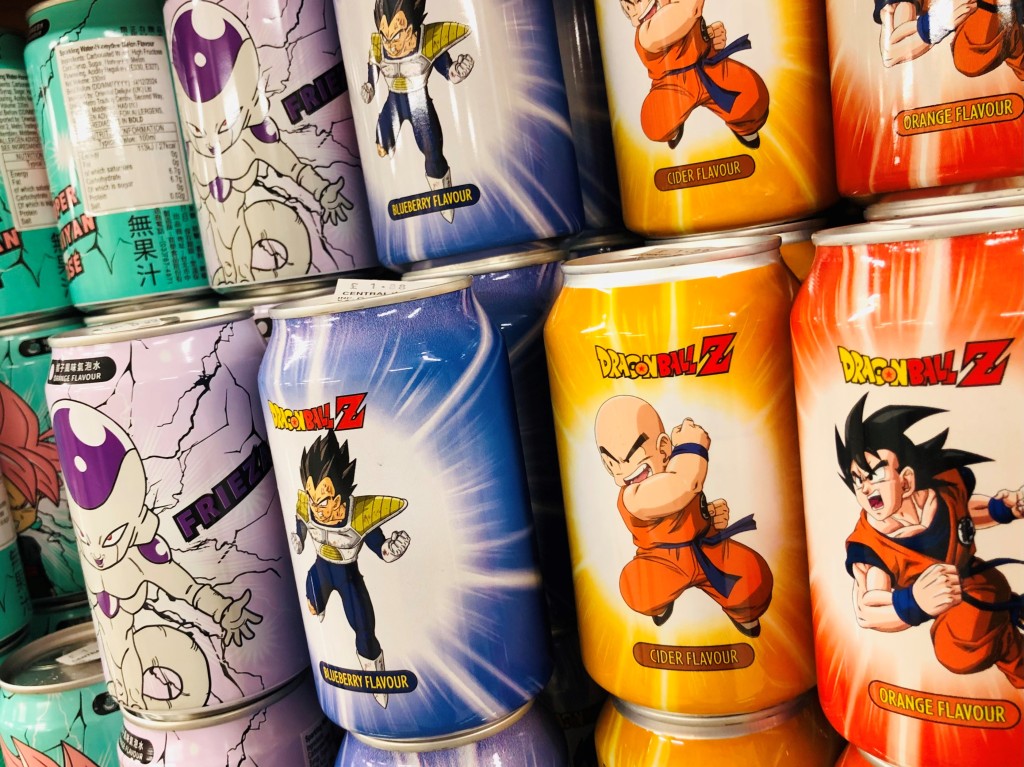 Picture shows a colour photo of cans of the Taiwanese soft drink Ocean Bomb in different flavours including orange, cider, blueberry, and melon. The cans feature artwork showing characters from the popular anime Dragon Ball Z.