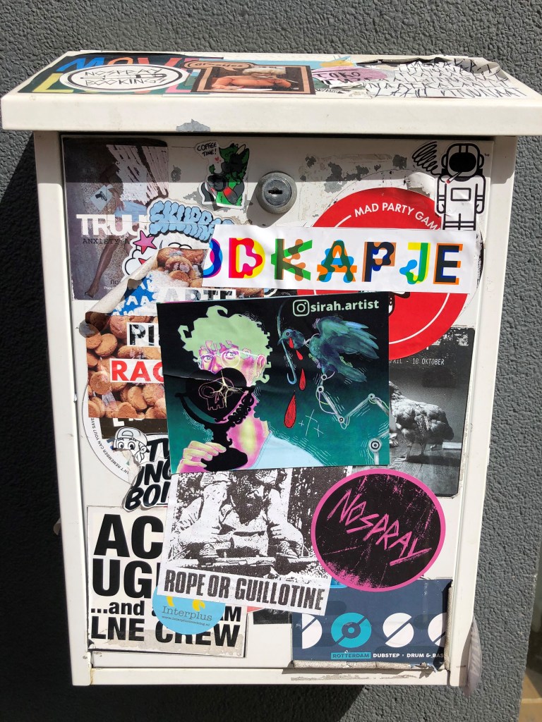 Picture shows a white mailbox almost entirely covered with stickers.